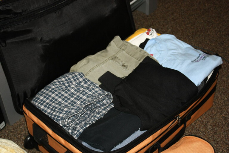 Beach vacation packing with suitcase and essentials