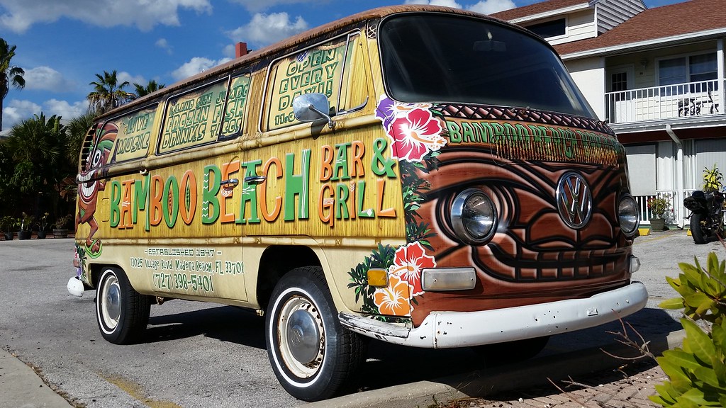 The Yucatan Beach Stand's colorfully painted tiki-themed VW bus parked outside the bar