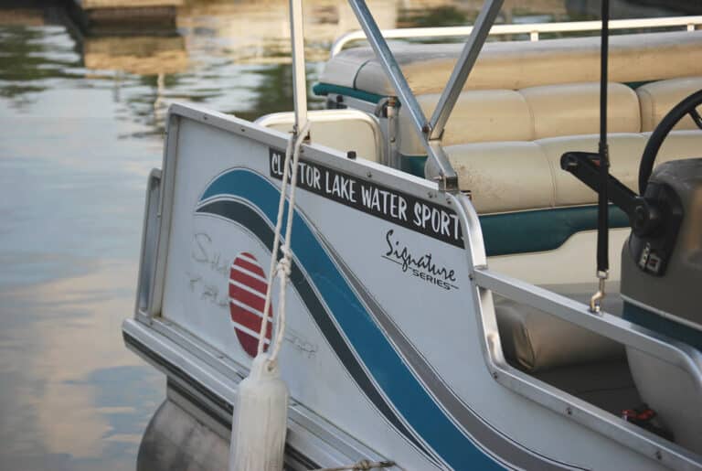 Pontoon rental boat tied up at a dock on calm water