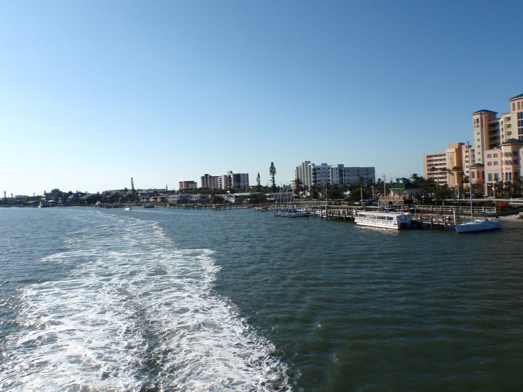 View across Matanzas Pass harbor toward the Fort Myers Beach waterfront from a departing boat