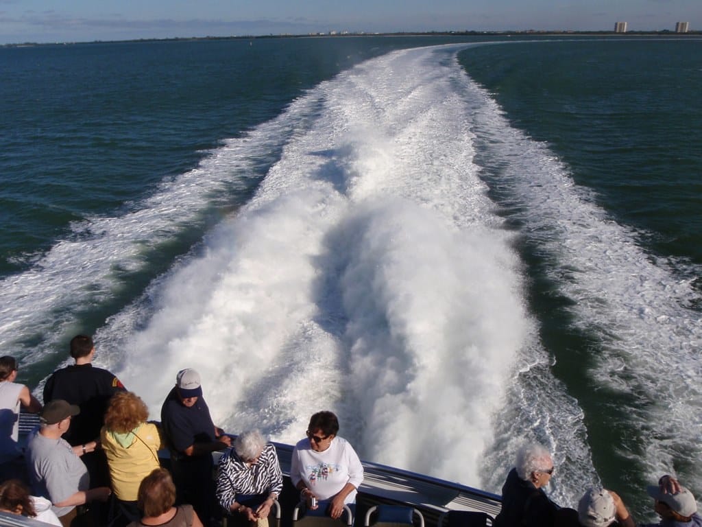 Passengers on the rear deck of the Key West Express ferry watching the wake as it leaves Fort Myers Beach