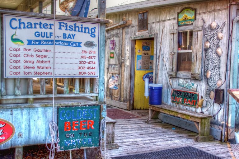 Weathered wooden charter fishing office on a Florida dock with a hand-painted captains' sign